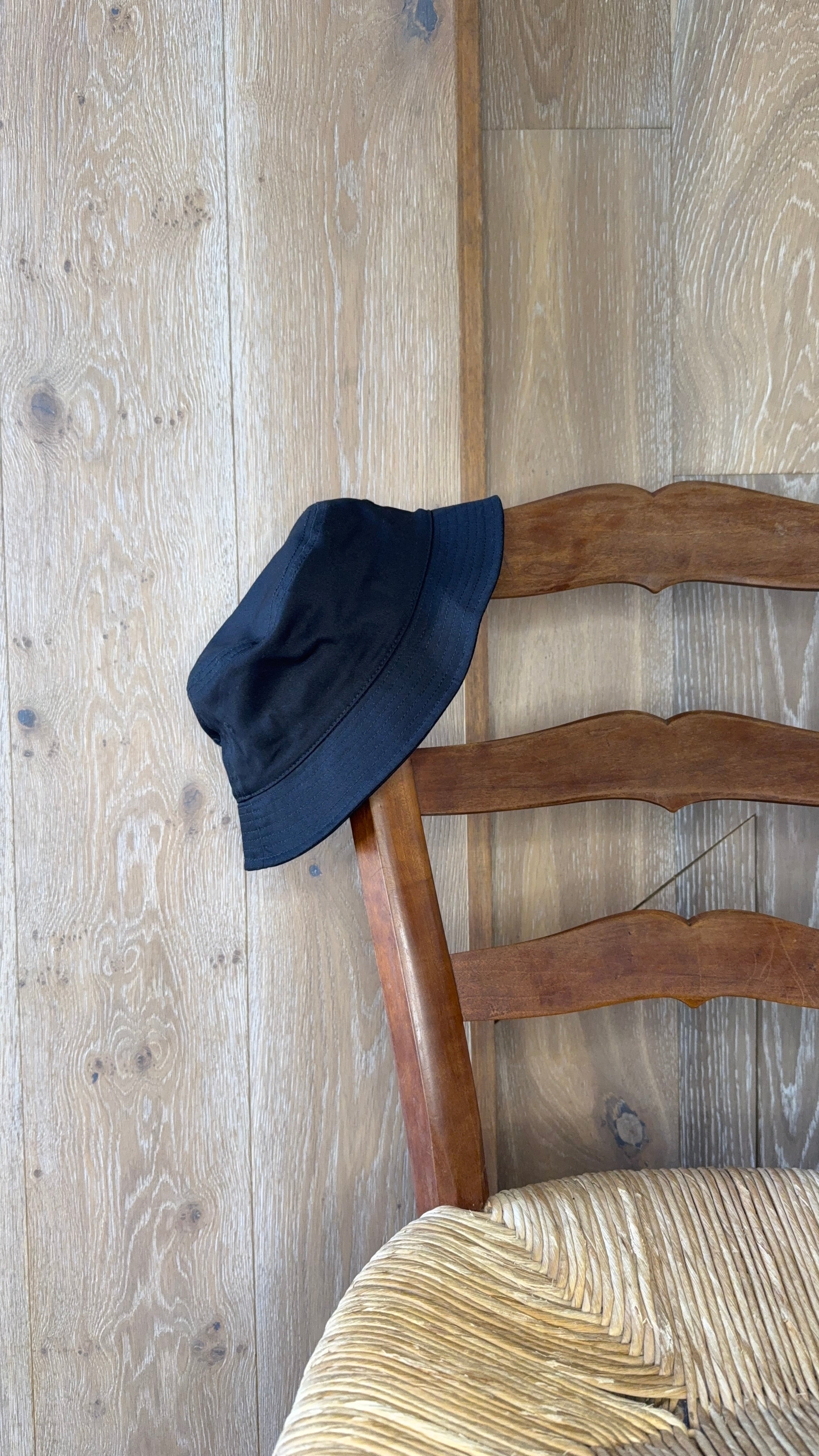 The black piluso from the side on a rush-seat chair.
