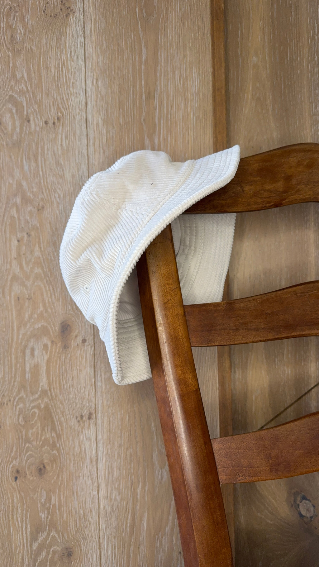The crema corduroy piluso from the side, brim and crown visible.