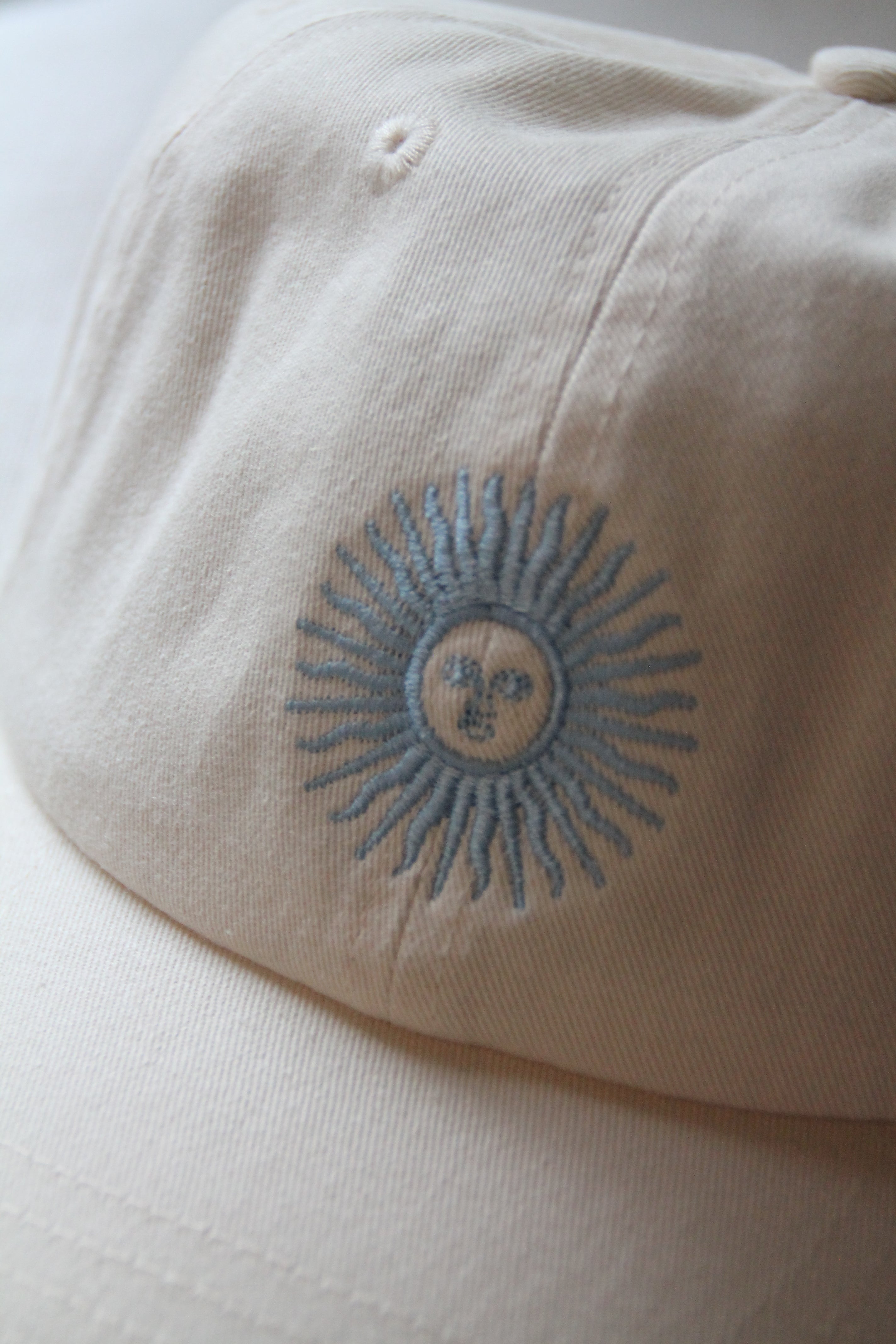 close-up of the light blue sol de mayo embroidery stitched on cream cotton twill