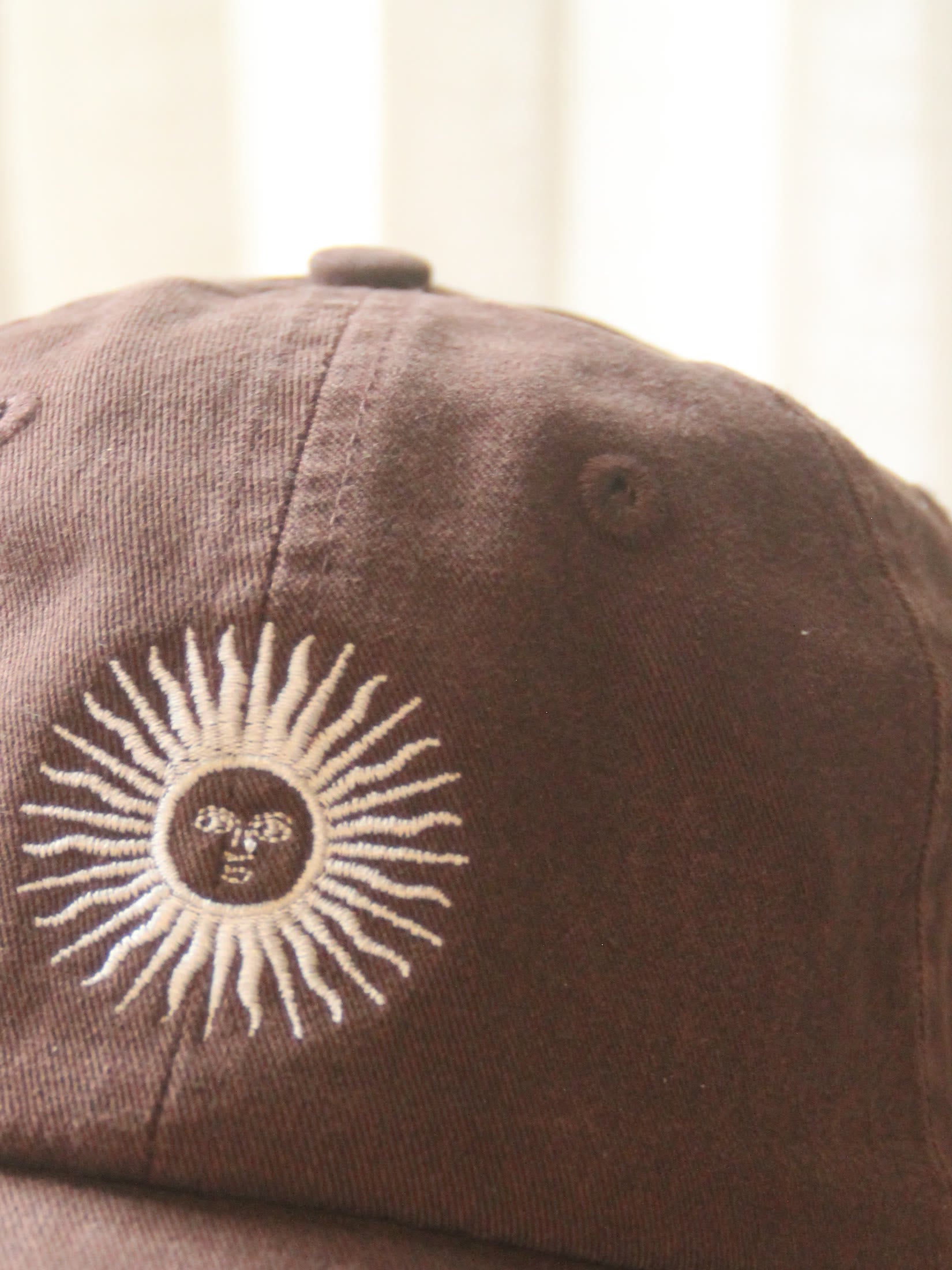 the sol de mayo, embroidered on the cacao cap